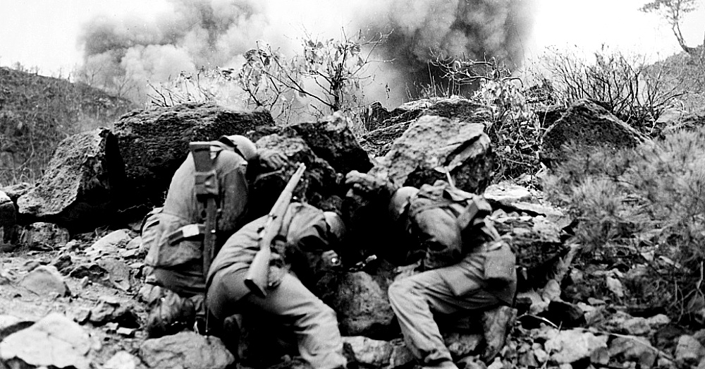 Men of the 3rd Battalion, 34th Infantry Regiment, 35th Infantry Division, covering up behind rocks to shield themselves from exploding mortar shells, near the Hantan River in central Korea / Via The Library of Congress