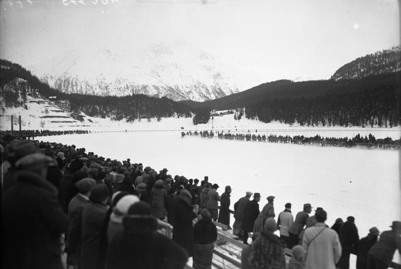 "Demonstration skijoring competition at the 1928 Winter Olympics, horses seen in the distance, coming around the bend of the track." From the German Federal Archives via Wiki Commons