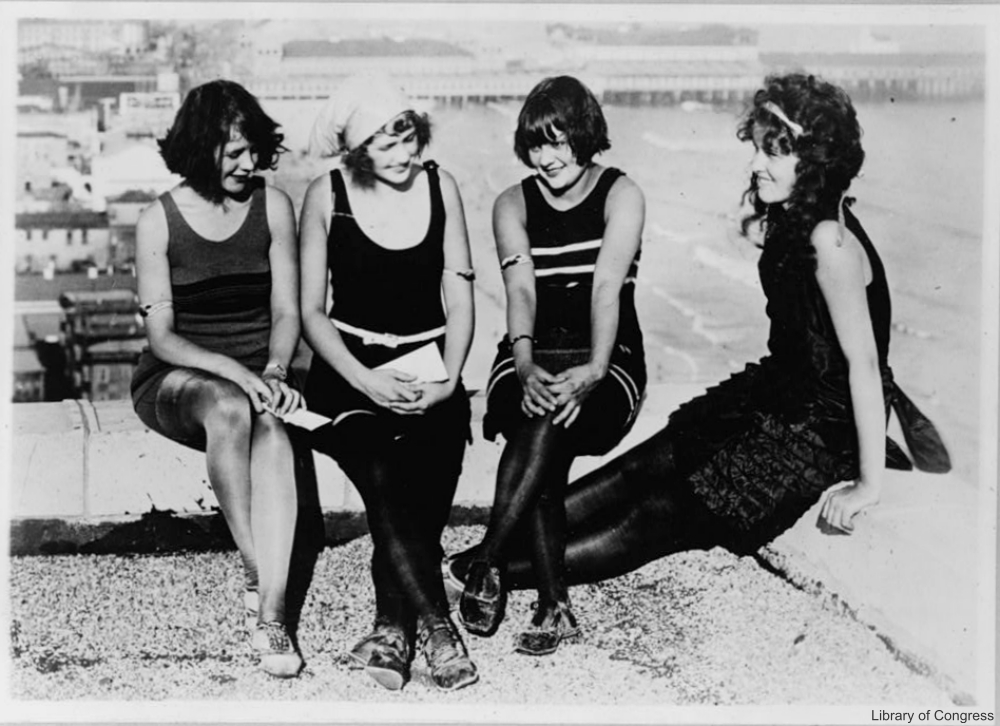 1920s women in swimsuits, still wearing stockings on public beach