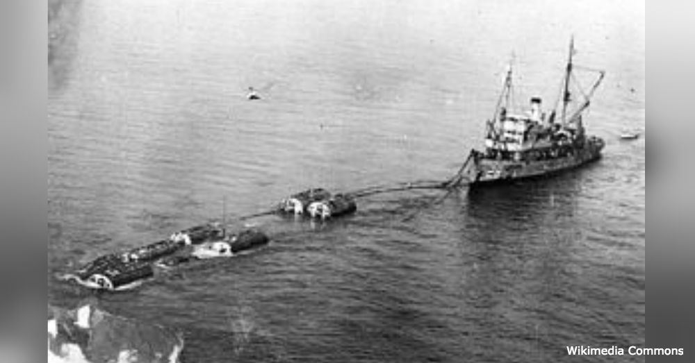 The damaged S-51 being transported below massive pontoons.