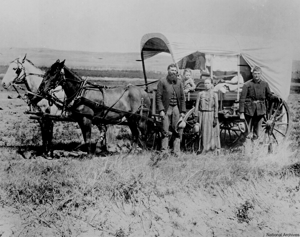 Settler family in front of their wagon.