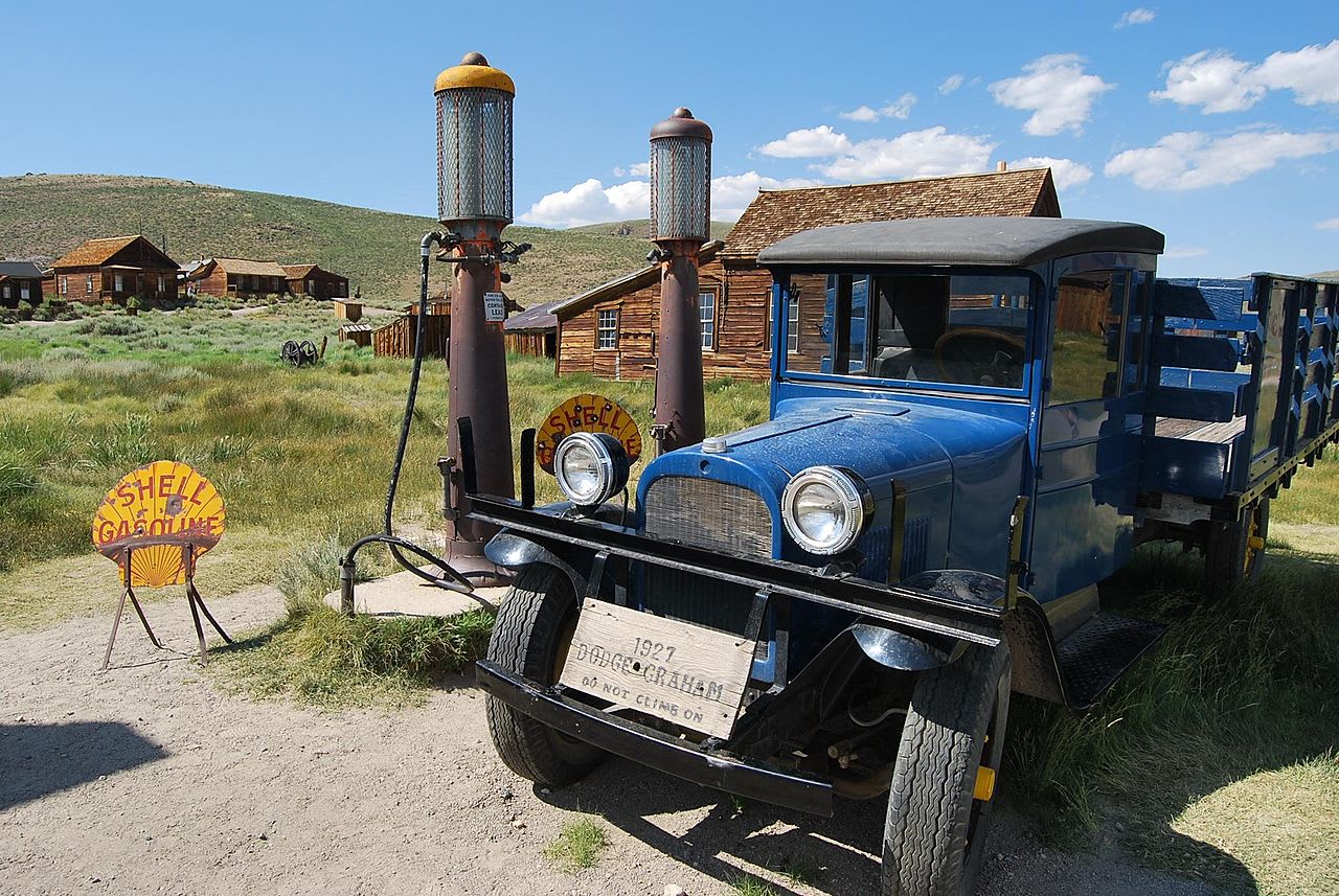 A Dodge Graham sits next to the old gas pumps. Note the bullet holes on the old