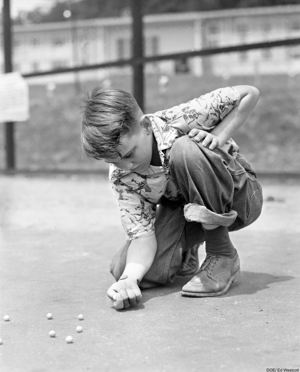 boy playing marbles on the ground