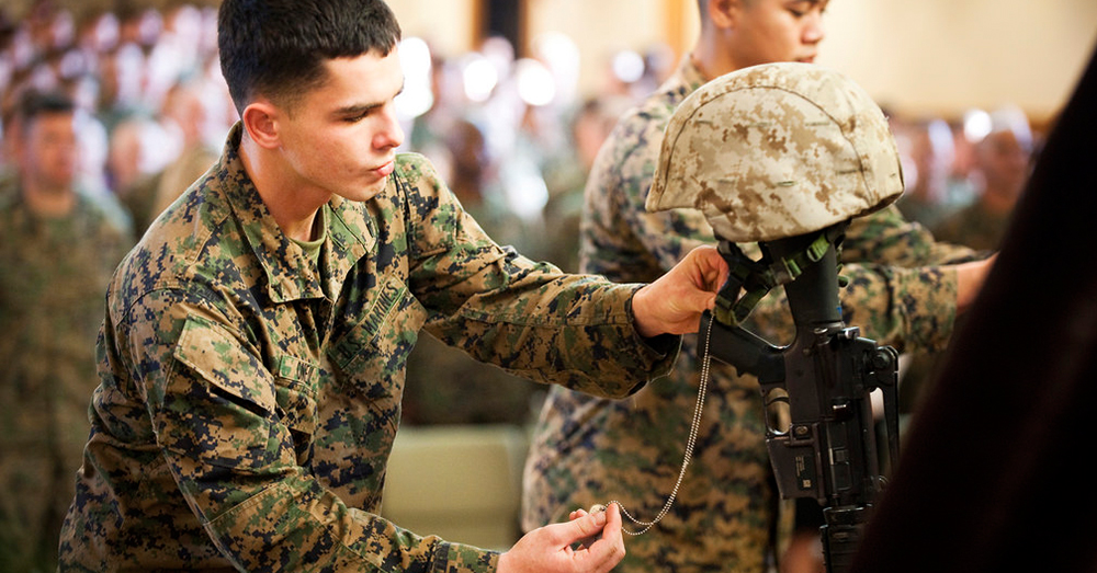 Photo: U.S. Marine Corps/Flickr -- Lance Cpl. Scott C. O'Neil places identification tags on Sgt. Joe L. Wrightsman's monument during a memorial ceremony.