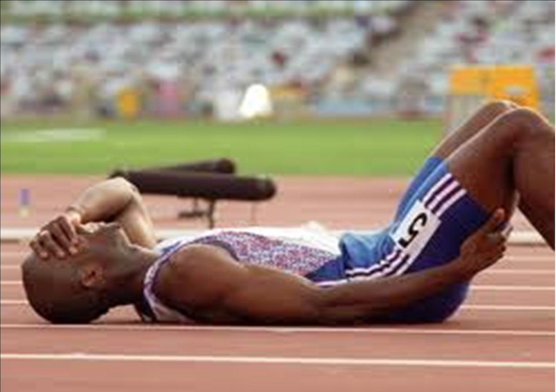 Derek Redmond lies fallen on the track.