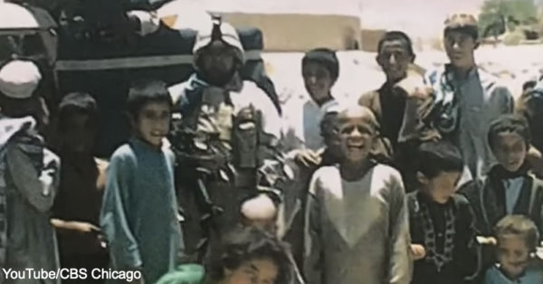 Army Private First Class Miguel Perez, Jr. surrounded by children in Afghanistan.