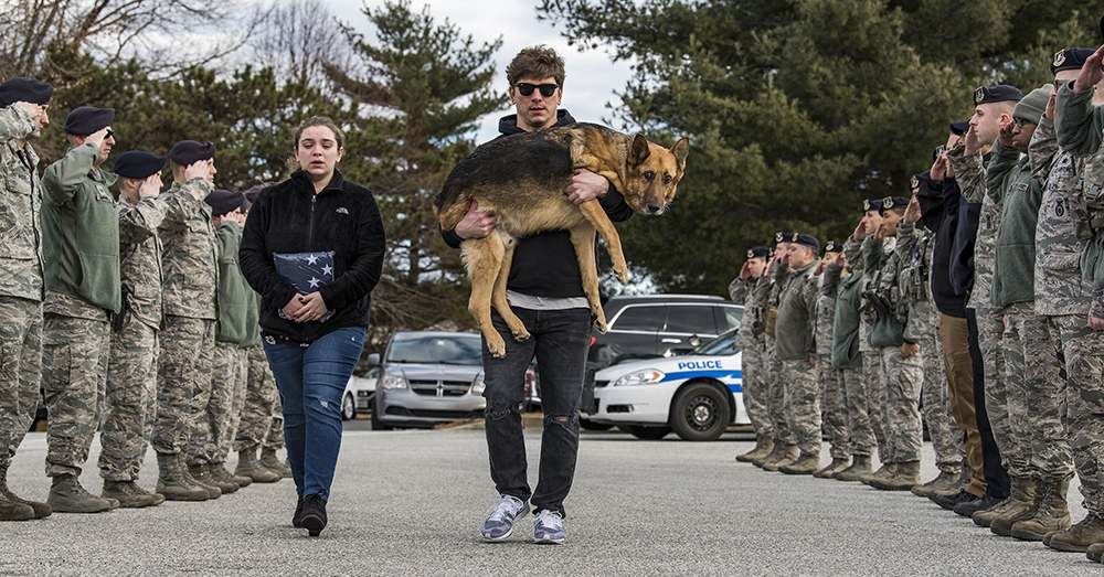 U.S. Air Force/Roland Balik -- Members of the 436th Security Forces Squadron render a final salute to retired Military Working Dog Rico as his former handler and current owner, retired Tech. Sgt. Jason Spangenberg, carries him to the Veterinary Treatment Facility on Dover Air Force Base.