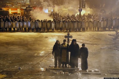 Orthodox priests stand between protestors and riot police in Kiev, Ukraine