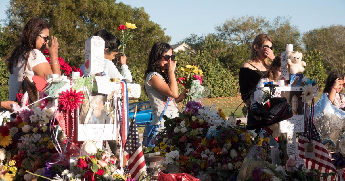 Students and teachers gather at a memorial for Marjorie Stoneman Douglas High School shooting victims
