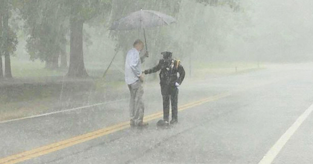 Source: InspireMore Kevin Hammett brings the officer an umbrella.