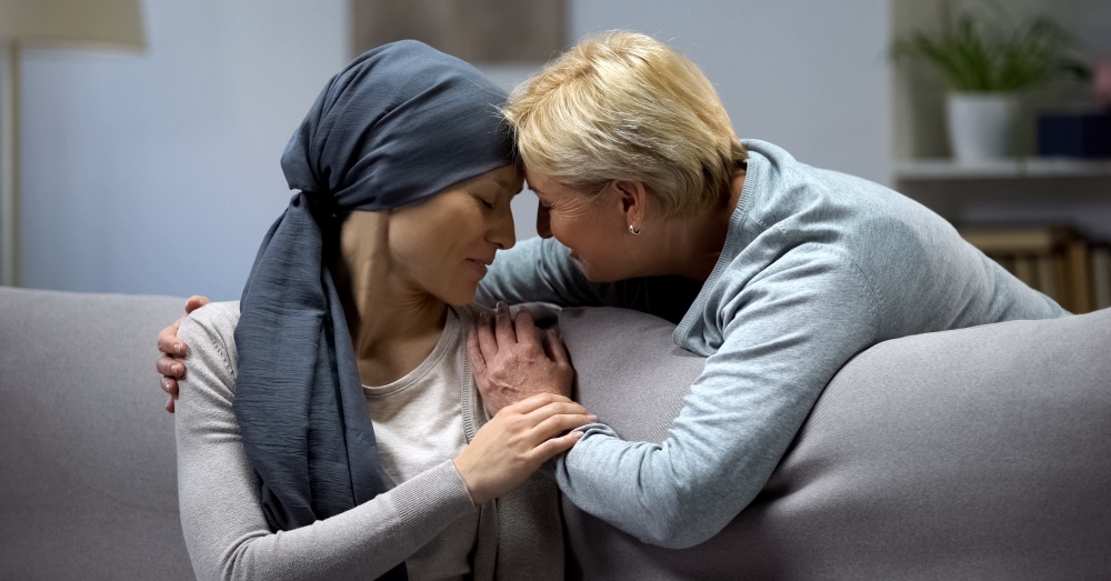 A woman embracing a female cancer patient in a show of support