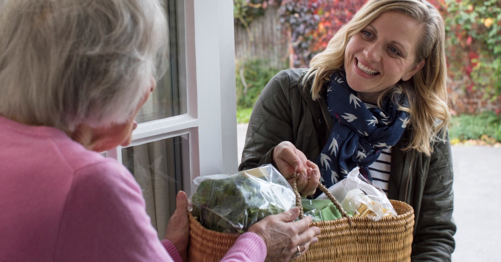 A woman delivering a package of groceries