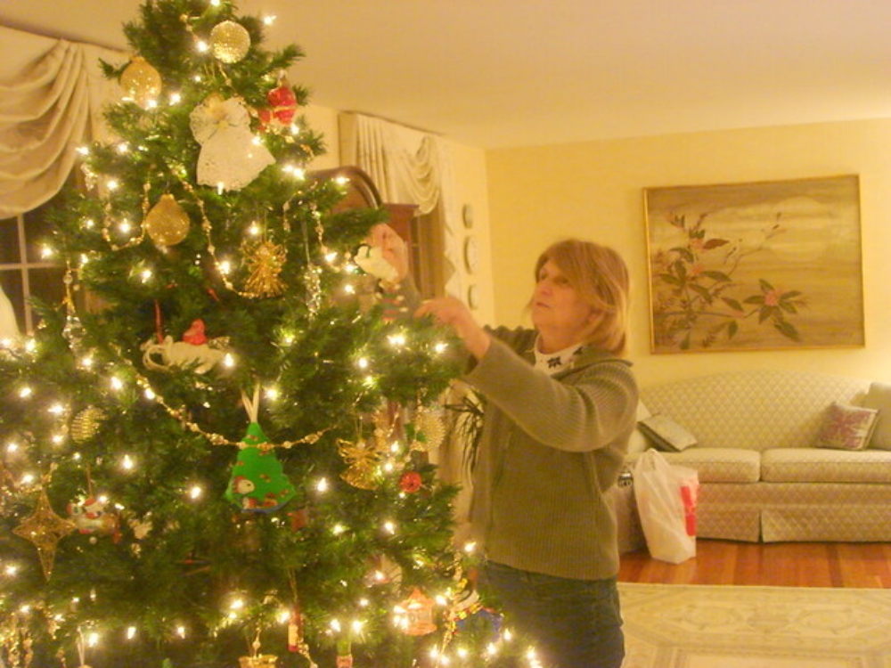 putting finishing touches on the Christmas tree