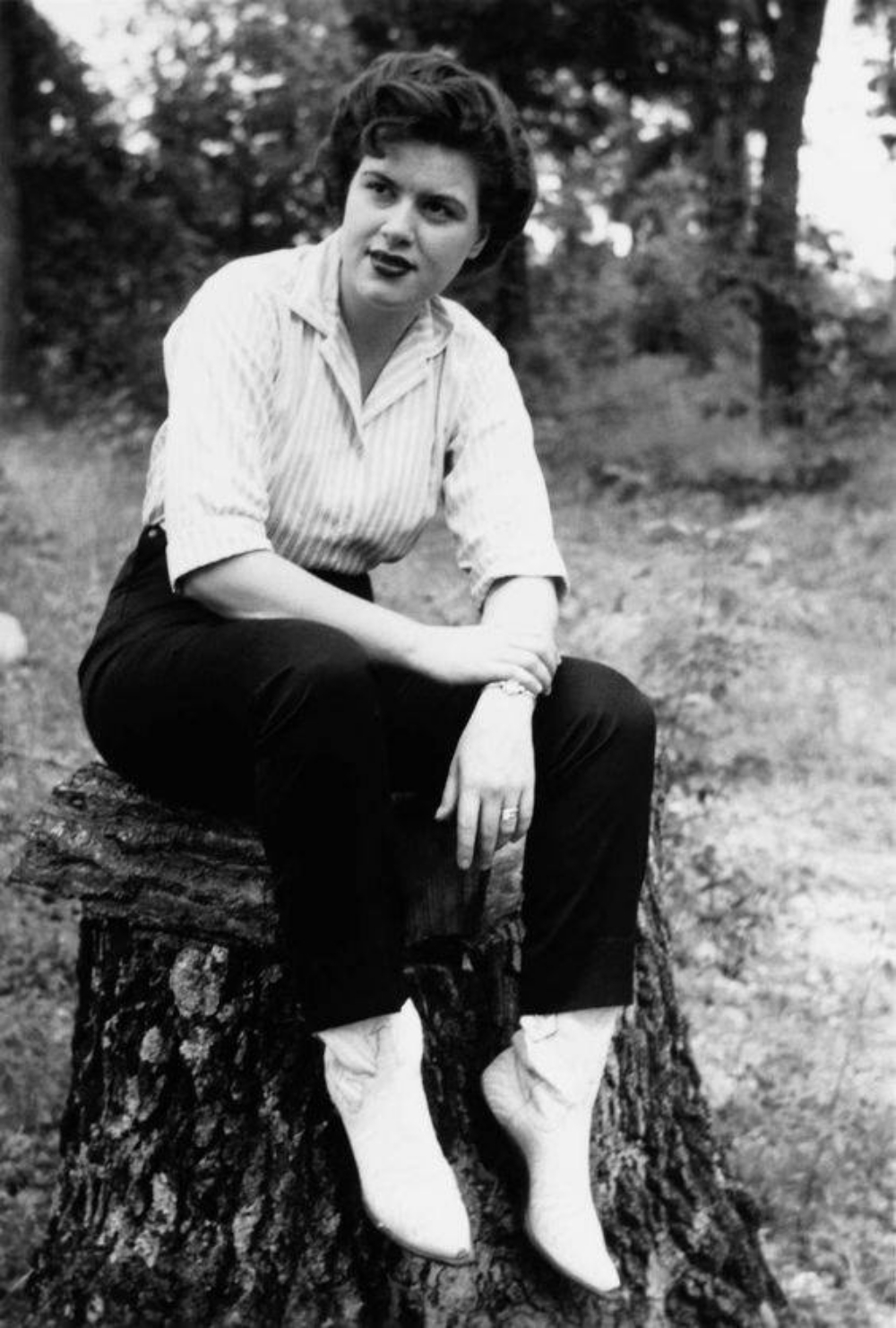 Patsy Cline sitting on a tree stump