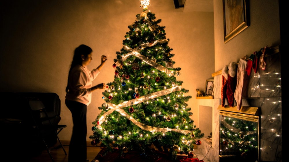 trimming the Christmas tree with ribbon and ornaments