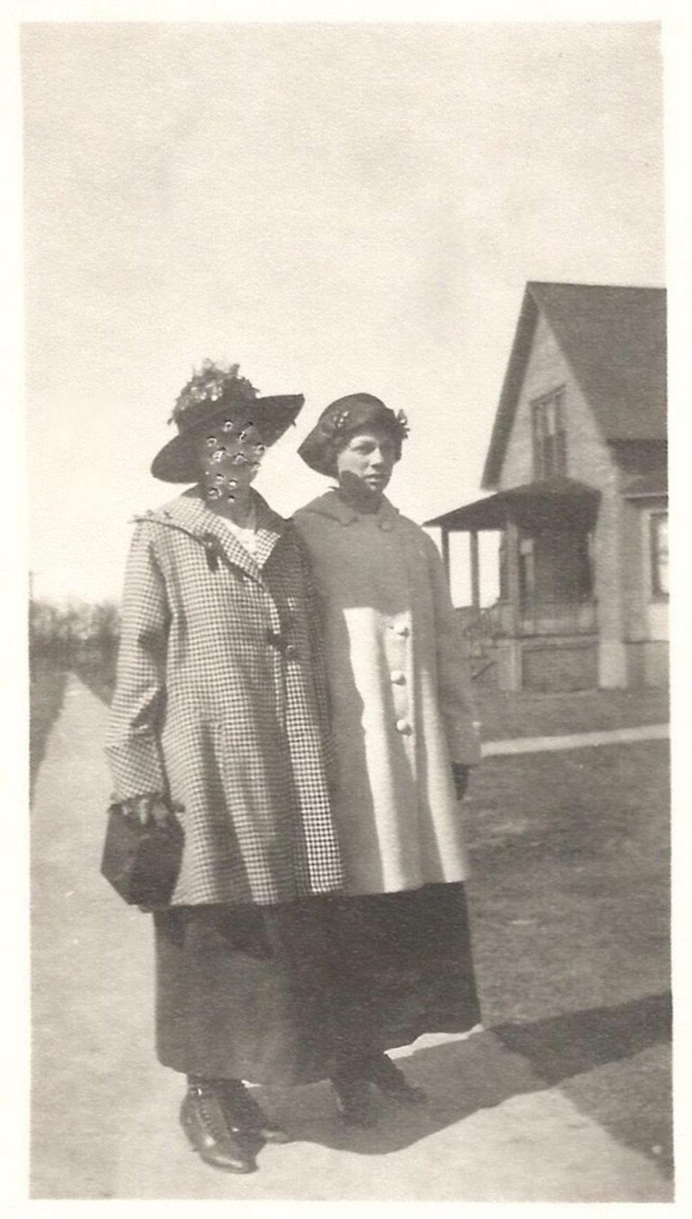 photo of two women in the 1920s, one with her face poked through