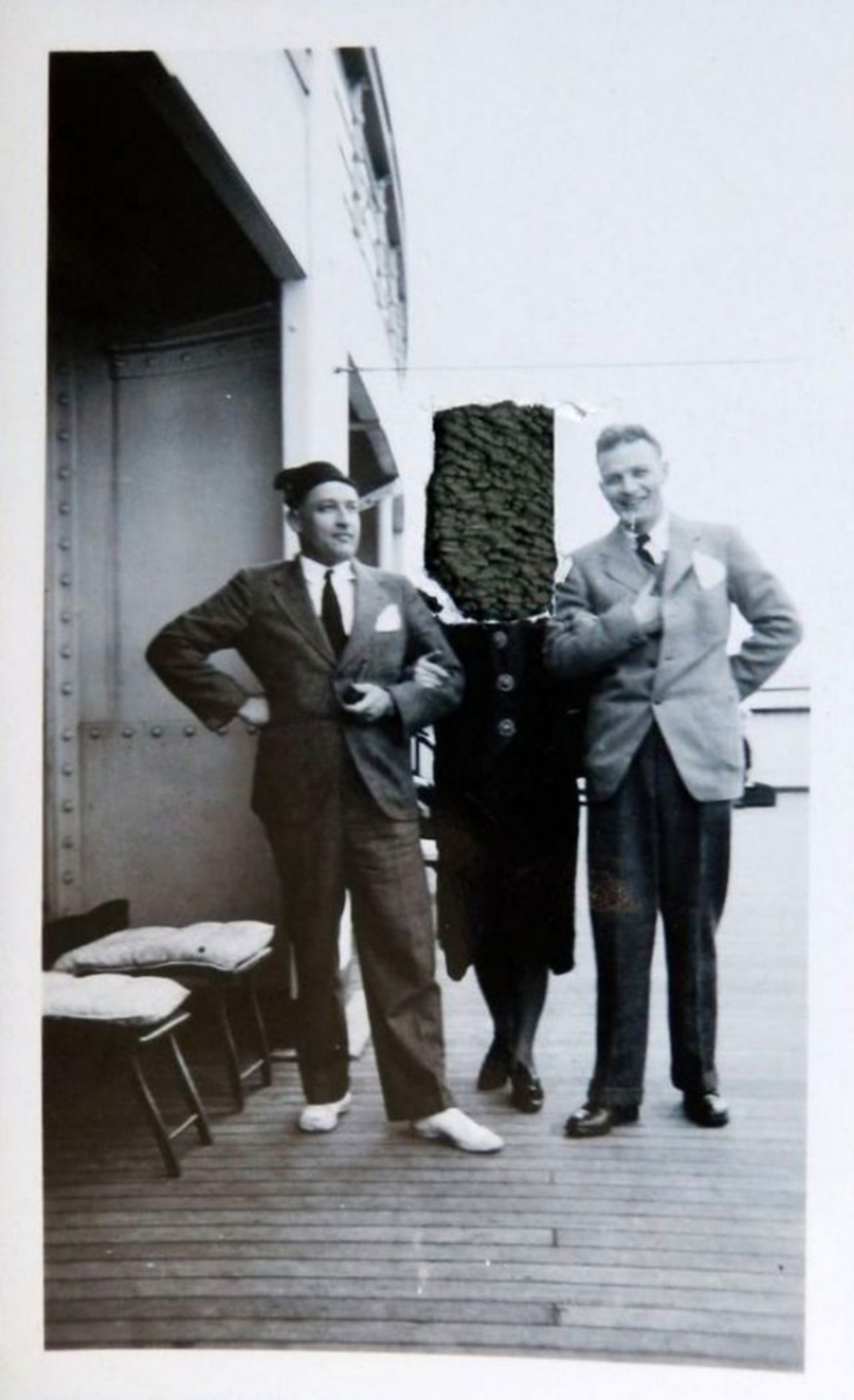 three people on a ocean liner, one with her face cut out of the photo