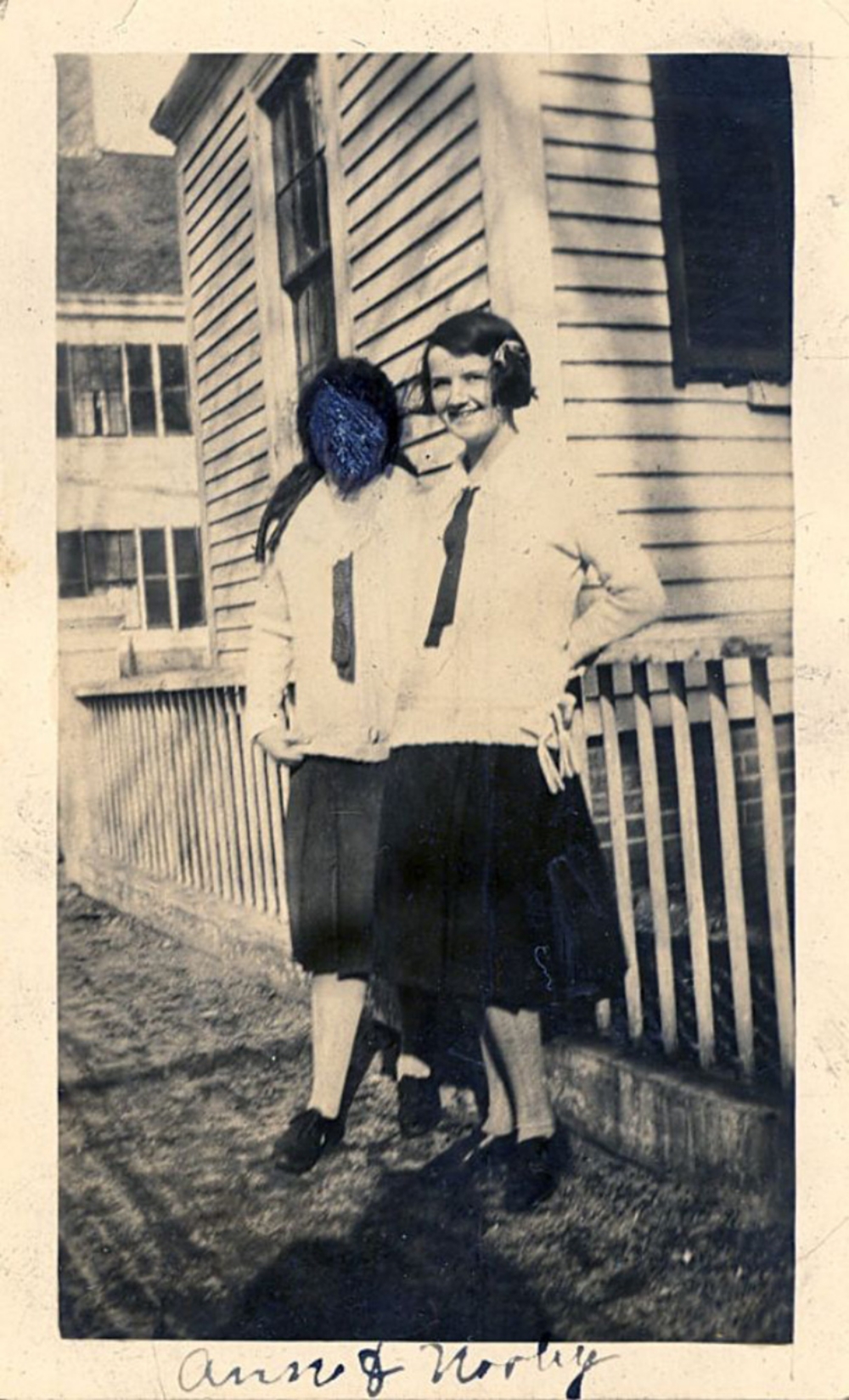 photo of two schoolgirls, one with her face marked over with blue pen