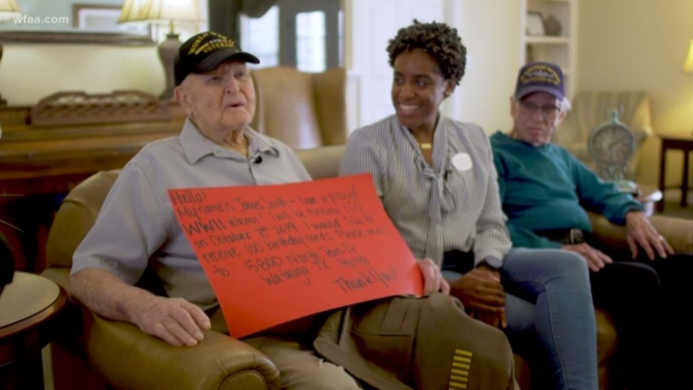 James South sitting on a couch with his sign