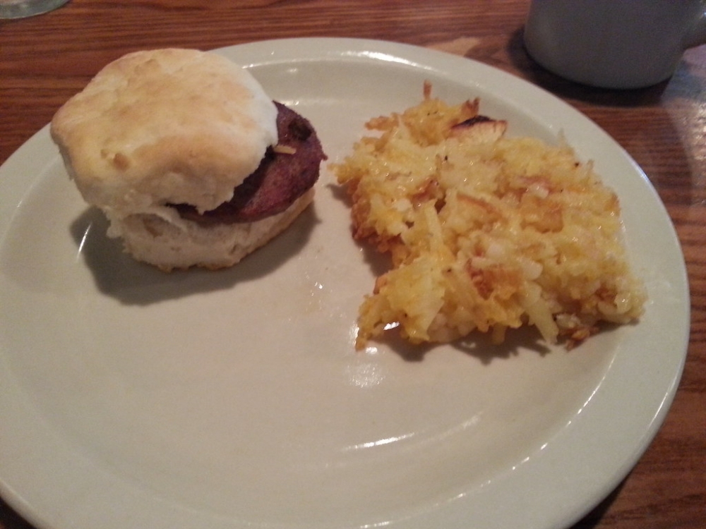 Hashbrown casserole served with a sausage biscuit at Cracker Barrel