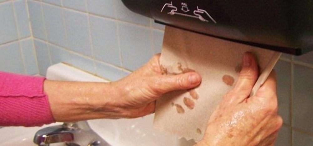 person drying their hands with paper towels