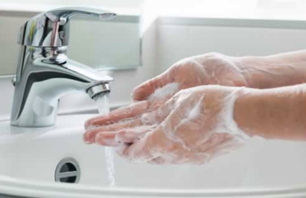 person washing their hands with soap