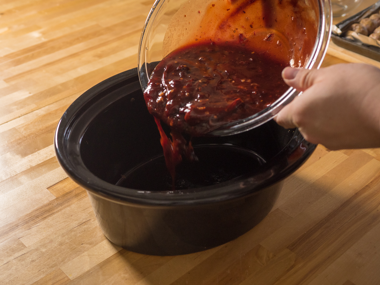 sauce for Slow Cooker Chipotle Meatballs being dumped into slower cooker