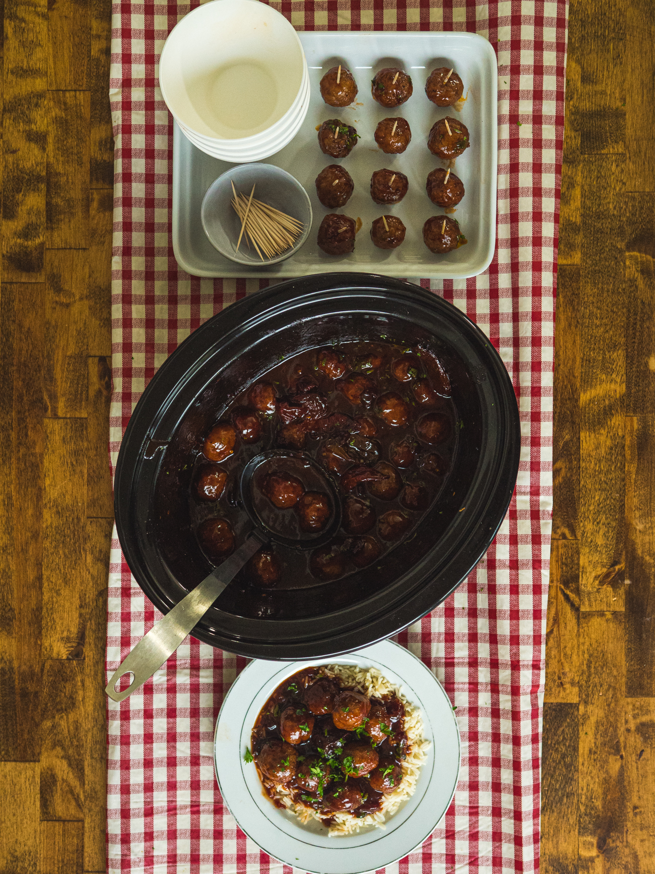 Slow Cooker Chipotle Meatballs on buffet spread with checkered tablecloth