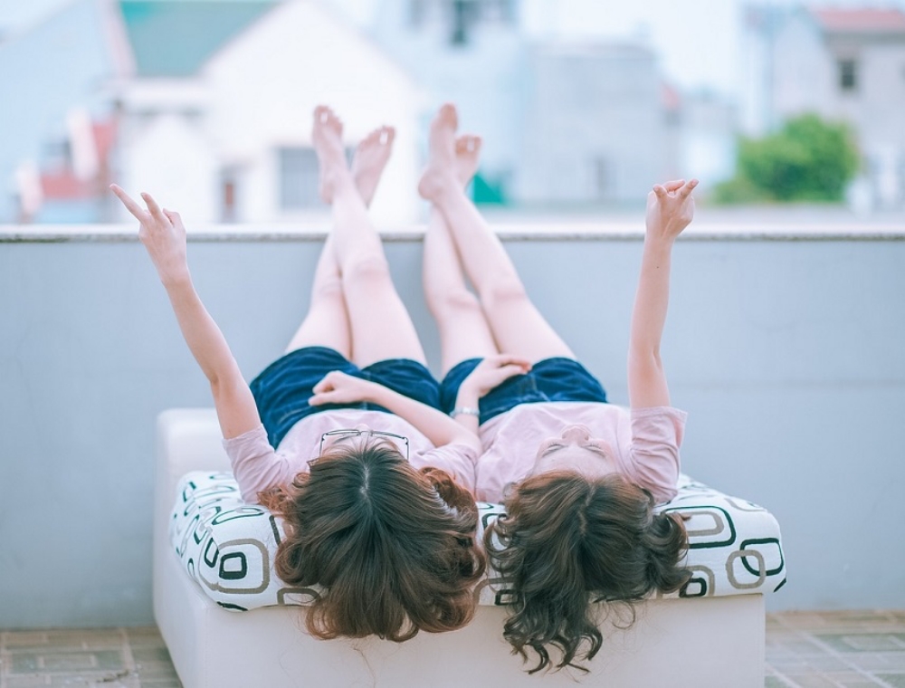 adolescent twin girls lying on a bed