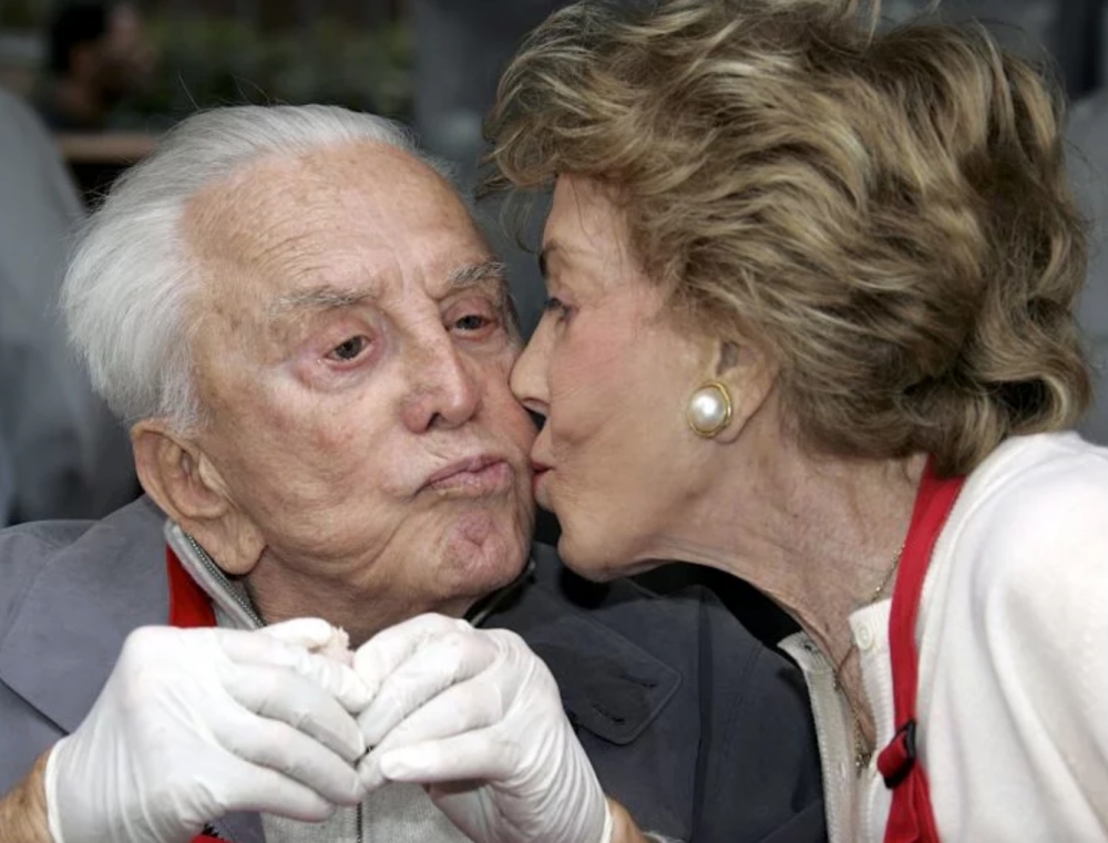 Anne Buydens giving her husband, Kirk Douglas, a kiss
