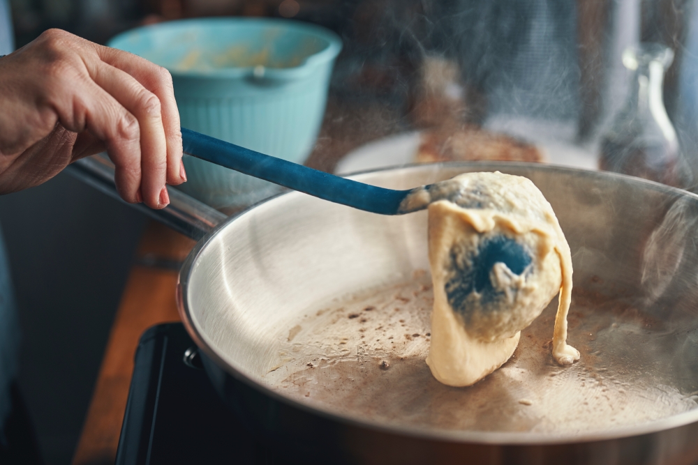 pouring pancake batter into a pan