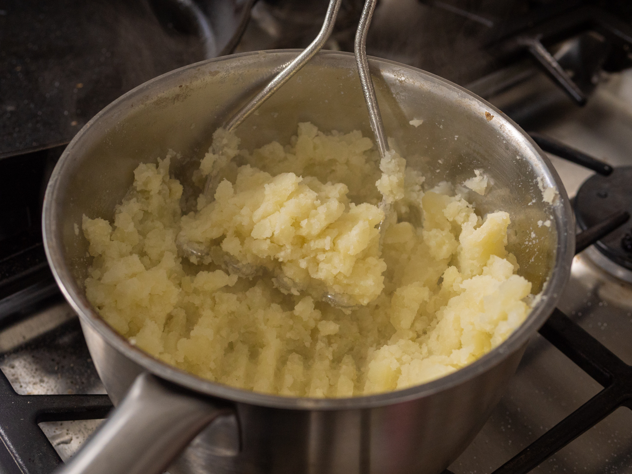 mashing potatoes to make Scottish Rumbledethumps