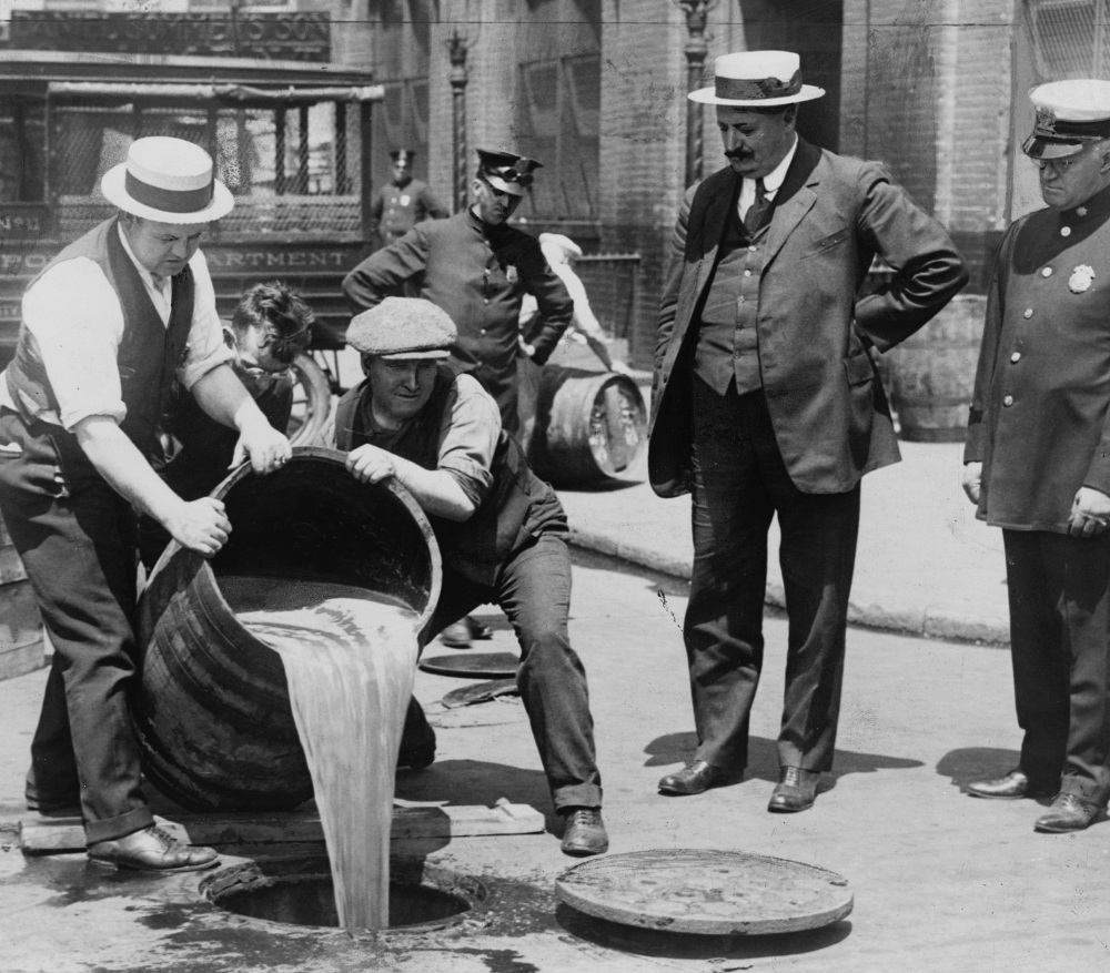 NYC police overseeing the emptying of barrels of liquor during Prohibition