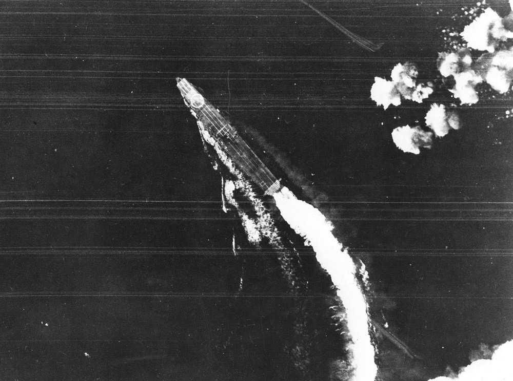 The Japanese aircraft carrier Hiryu maneuvers to avoid bombs dropped by USAAF Boeing B-17E Flying Fortress bombers during the Battle of Midway.