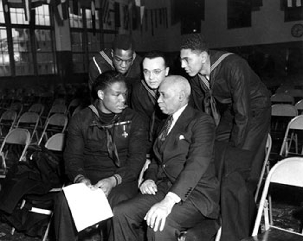 Miller speaking with sailors and a civilian at Great Lakes Naval Training Station, January 7, 1943.